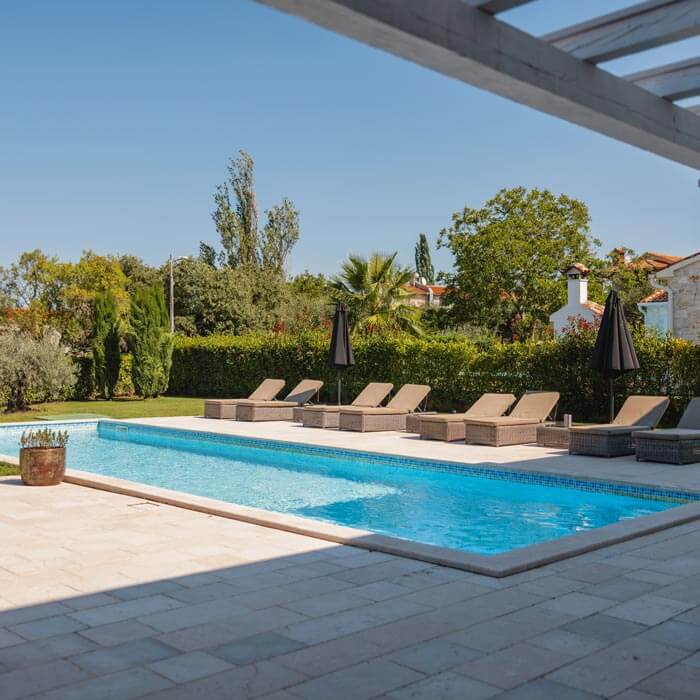 rectangular pool in backyard with trees