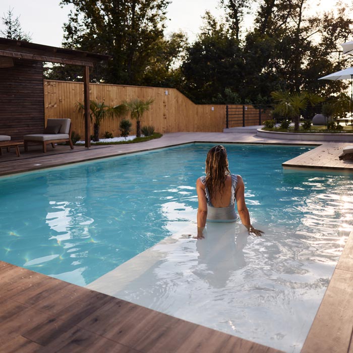 Back view of carefree woman relaxing in the pool in Naples, FL